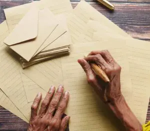 We see the hands of an older woman holding a pencil as she writes the story of VM Canada.