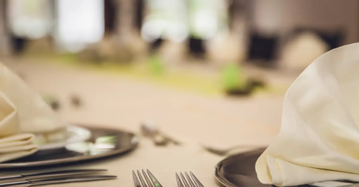 A refined dining table setting with neatly folded napkins and cutlery on elegant plates.