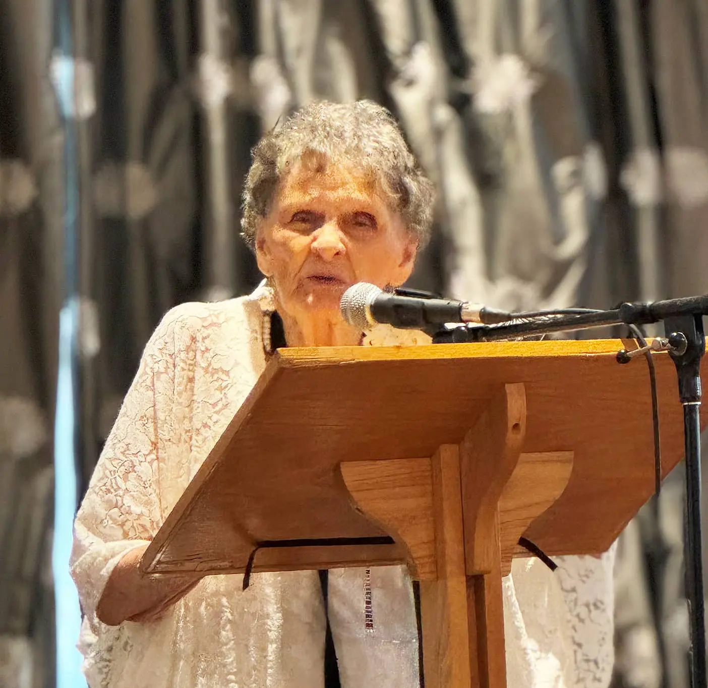 Ethel Wright stands behind a podium while encouraging others to support rural church ministry in Canada.
