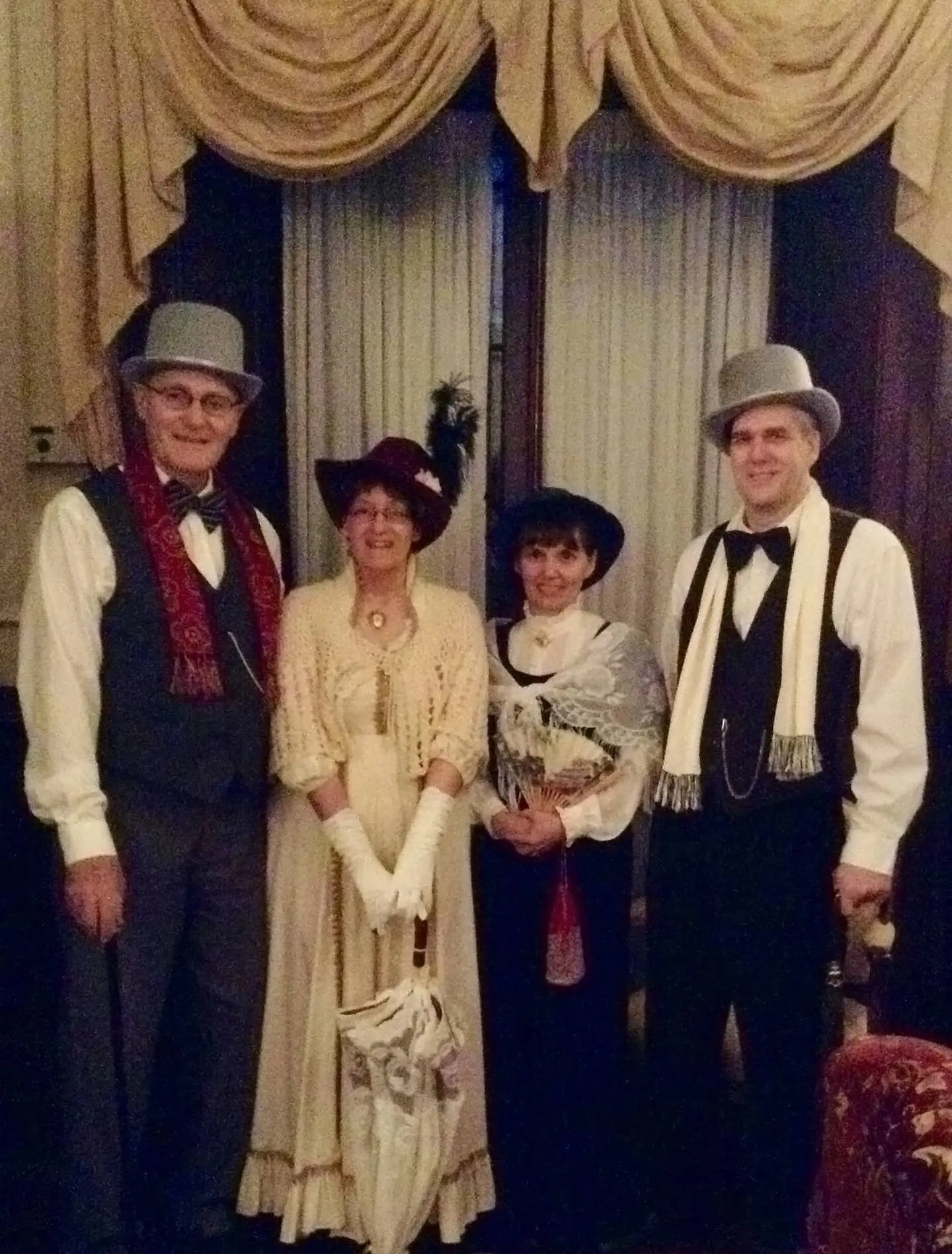Two couples wearing clothing to match the "pioneer" theme at an event.