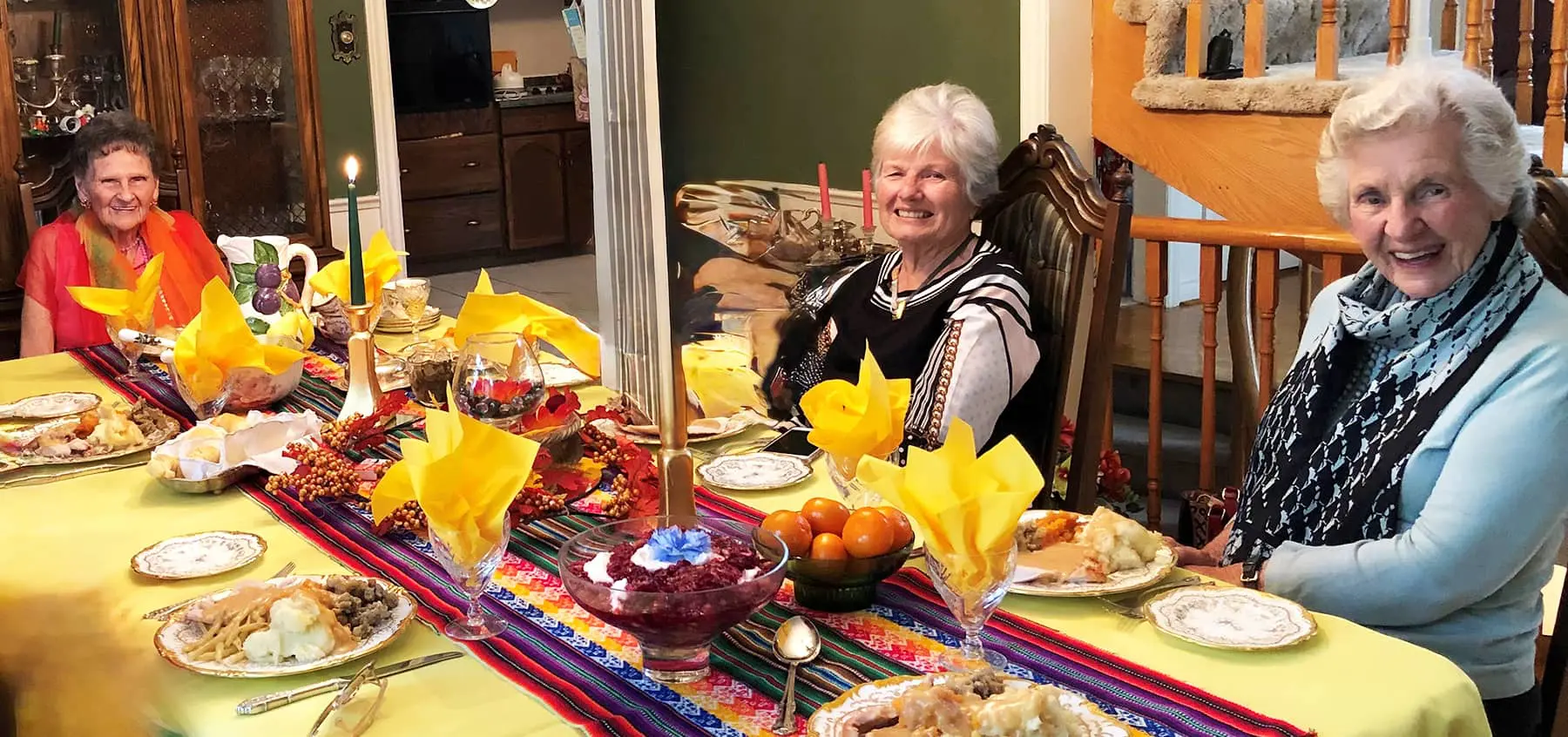 Three members of the Toronto Christian Women's Club enjoy a meal at a table decorated for a mexican meal.