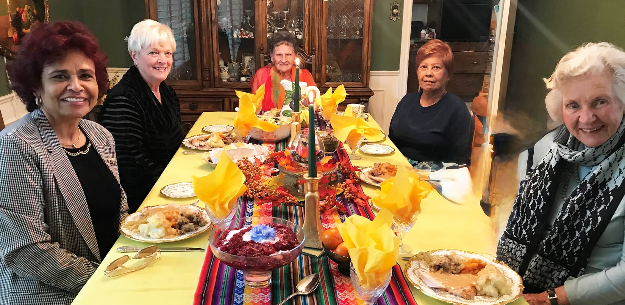 Barbara Mendes is shown with a group of women, including Ethel Wright, at a beautifully decorated table. They are discussing supporting rural church ministry in Canada.